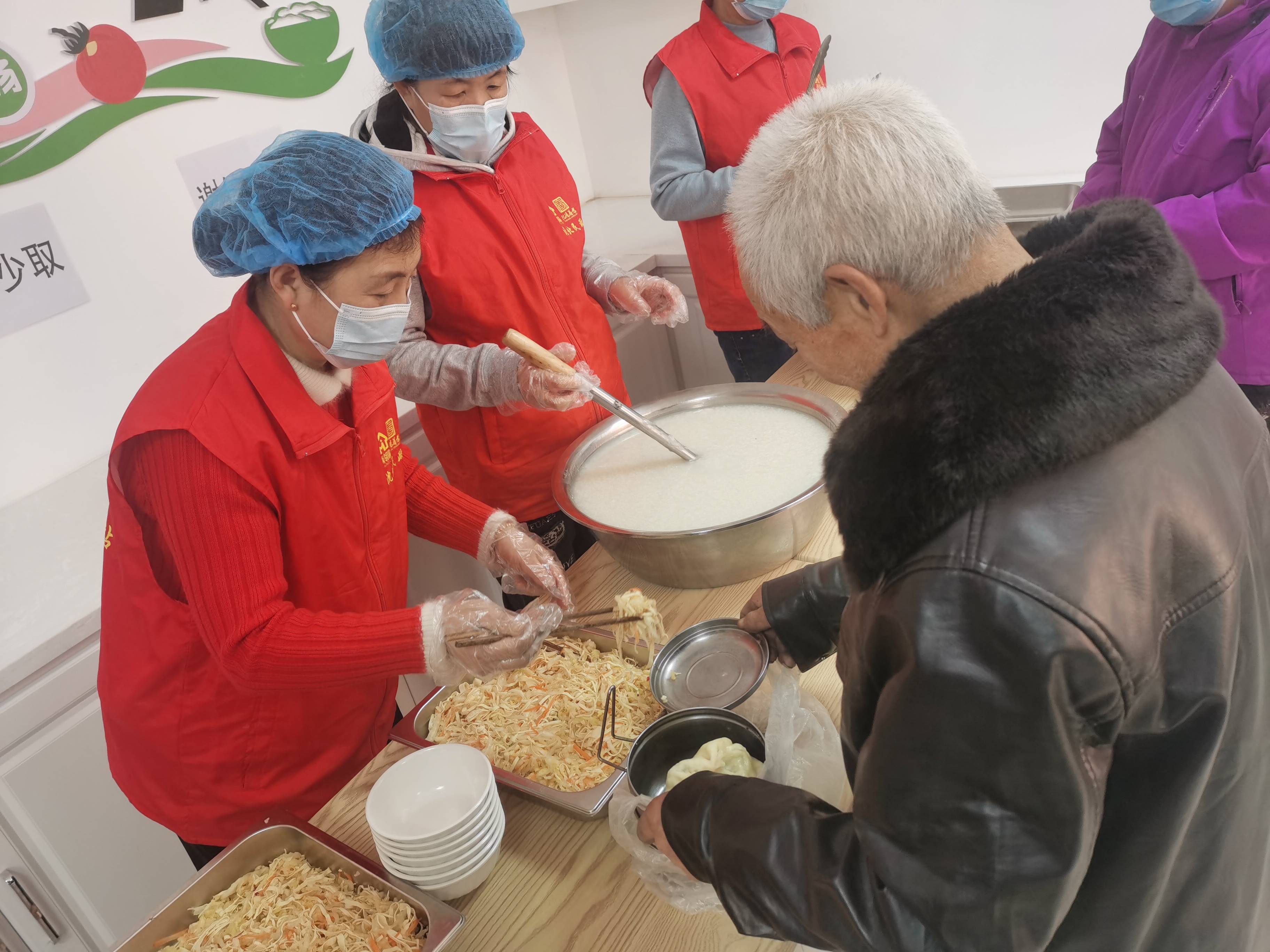 图二:颇家屯村幸福长者食堂工作人员为老人打饭.jpg